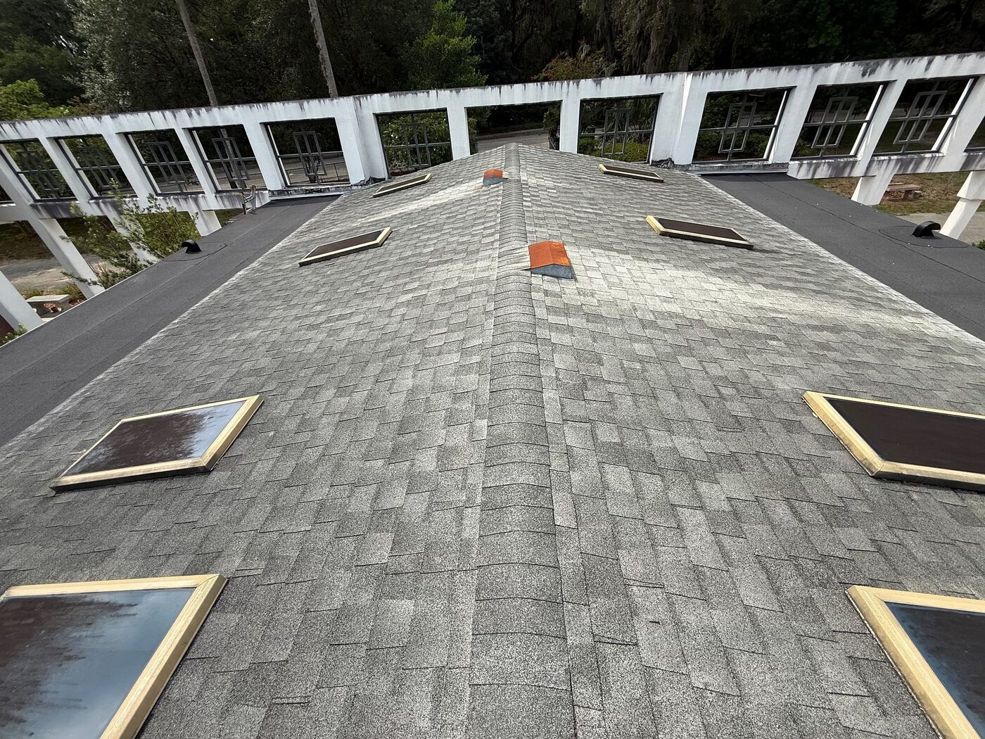 An aged shingle roof section with skylights at the memorial campus.