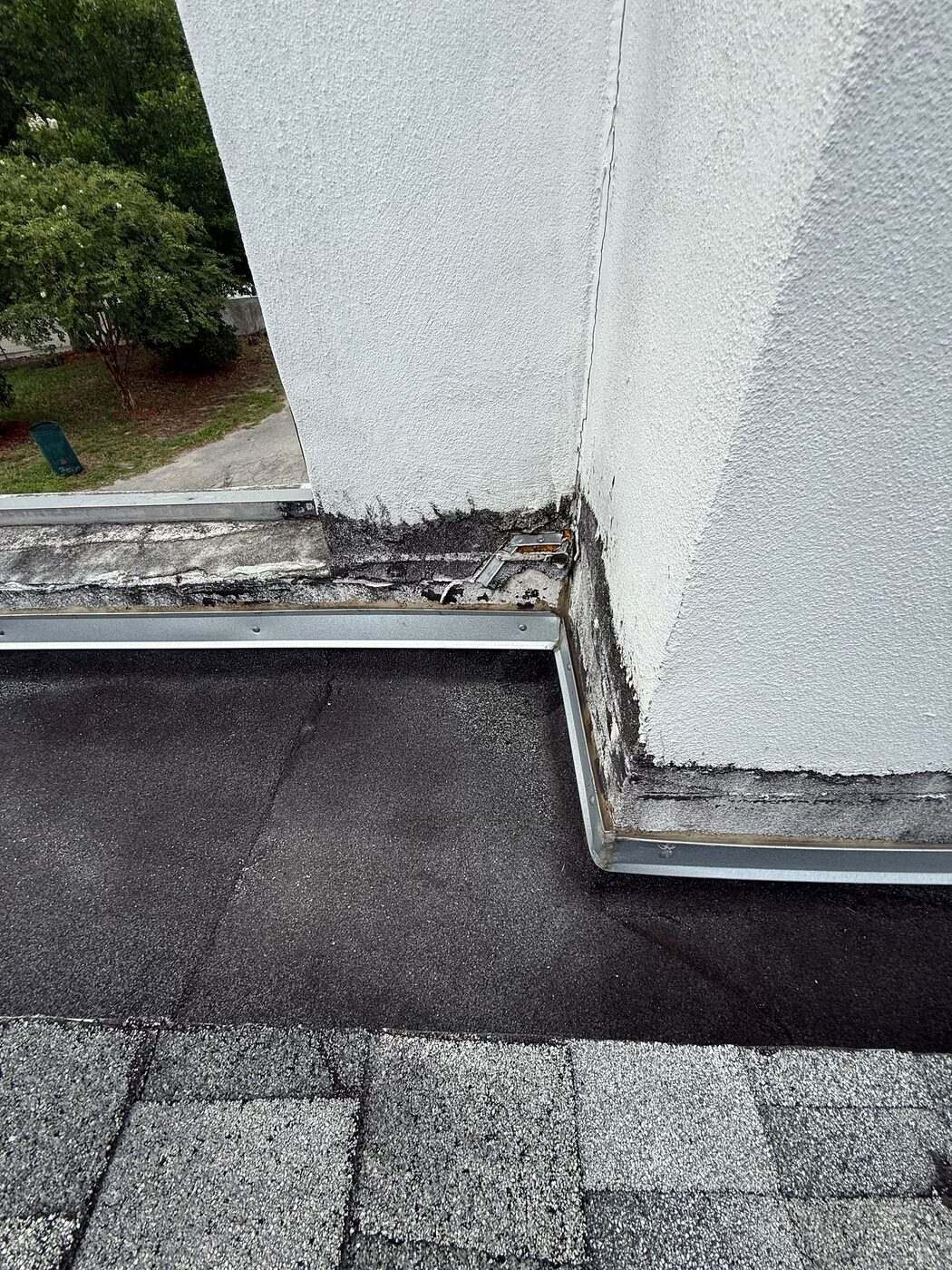A wall and roof flashing condition identified for repair or replacement planning.